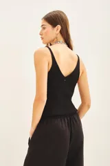 Musculosa de tejido rib al cuerpo con escote en V y detalle de lentejuelas bordadas a tono.