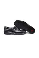 Zapato formal tipo mocasín de cuero negro, con puntera cuadrada y suela de goma. Presenta un diseño slip-on con elástico lateral para facilitar el calce.
