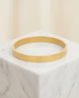 Pulsera tipo esclava rígida de acero con baño de oro, con diseño de líneas paralelas y acabado pulido.