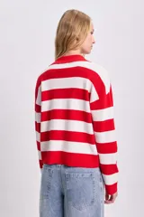 Sweater de punto a rayas horizontales rojas y blancas, con cuello polo y mangas largas.