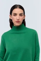 Polera tejida de punto confeccionada en lambswool color gris claro, con cuello alto y calce holgado.