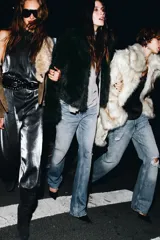 Top asimétrico color gris claro, con escote de un solo hombro. Presenta un tirante ancho decorado con lentejuelas plateadas que cae sobre el pecho y se anuda al cuello tipo halter.