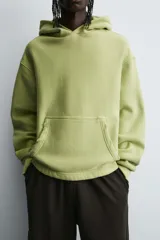 Sudadera tipo hoodie con efecto lavado, corte cropped y ajuste holgado. Cuenta con capucha, bolsillo frontal tipo canguro y terminaciones en rib en mangas y ruedo. Interior afelpado.