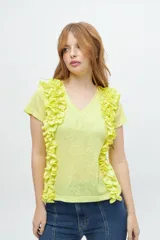 Remera color amarillo con escote en V y volantes laterales.