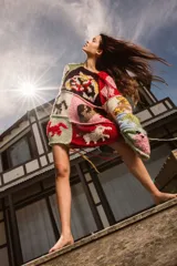 Sweater de lana tejido y bordado a mano con diseño patchwork de animales y motivos geométricos en tonos rojo, verde, marrón, beige y negro.