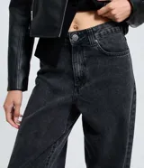 Pantalón de jeans para mujer, modelo baggy de cintura media, confeccionado en algodón con efecto deslavado. Presenta cinco bolsillos y cierre tradicional.