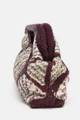 Bolso de mano tipo sobre con estructura rígida, decorado con un patrón geométrico de rombos bordados en cuentas color bordó y detalles brillantes en el interior. Cuenta con doble asa rígida integrada y cierre mediante botón imantado.