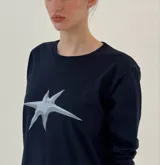 Remera de manga larga color azul marino, con cuello redondo y estampado de estrella en color blanco en el centro del pecho.
