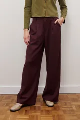 Pantalon de corte recto y pierna ancha, confeccionado en tejido tipo denim oscuro. Presenta tiro alto, cintura con cierre frontal y bolsillos laterales funcionales.