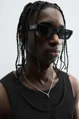 Camiseta sin mangas (tank top) negra, de corte slim fit, con cuello redondo de efecto doble.