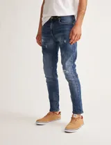Jean azul con efecto lavado y roturas, de corte ajustado.
