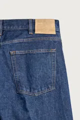 Jeans de denim azul oscuro sin lavados, corte recto con raya frontal planchada, tiro medio, cinco bolsillos y cierre frontal de botonadura. Colección especial Aaron Levine x Zara.