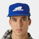 Gorra azul marino con visera curva y cierre ajustable en la parte posterior. Cuenta con un escudo bordado en hilo blanco en la parte frontal con la inscripción "EMESTUDIOS".