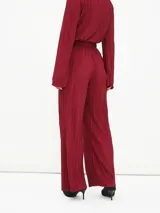 Pantalón de vestir color borgoña, de corte palazzo y tela plisada.