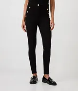 Pantalón legging negro de punto roma, con cintura alta y botones metalizados decorativos en los laterales.