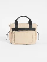 Bandolera color beige con asas negras y correa regulable extraíble. Cuenta con un estuche frontal removible, bolsillos laterales de malla con cordón ajustable, doble cierre y un bolsillo delantero.