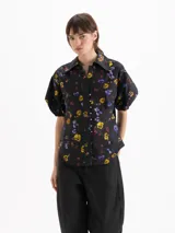 Camisa de poplín negro con estampado floral multicolor, de calce entallado, cuello clásico y mangas cortas abullonadas con puños elásticos.