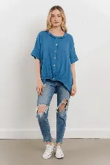 Blusa azul de lino con cuello fruncido, mangas cortas relajadas y base elastizada.
