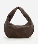 Bolso tipo baguette de formato curvo, confeccionado en poliuretano con acabado que imita el cuero. Presenta una estructura flexible con asa integrada y cierre superior metálico aparente que recorre el contorno.