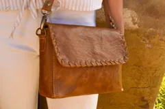 Bandolera de cuero color camel con correa larga regulable.