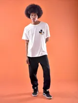 Remera blanca de corte oversized con estampado de Mickey Mouse estilo graffiti en el pecho.