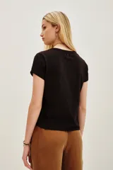 Remera de algodón color marrón oscuro con escote en V y dos apliques bordados en forma de corazón en el frente.