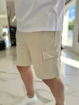 Bermuda cargo de jogging color beige, con bolsillos laterales y cordón ajustable en la cintura.