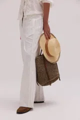 Pantalón de lino lavado color beige, de calce recto y diseño relajado. Presenta cintas de lino desflecadas aplicadas en los laterales con pespunte central, pretina con botón metálico, bolsillos delanteros y traseros.
