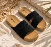 Sandalias planas con base marrón y tiras cruzadas en color beige de textura suave.