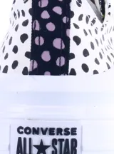 Championes Converse modelo Ctas Move OX con plataforma, diseño de estampado de puntos negros sobre base blanca y detalles en verde neón. Presentan cierre con cordones y puntera de goma blanca.