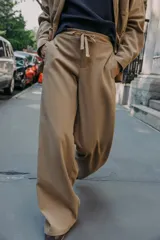Pantalón de tiro alto con corte wide leg, elástico en la espalda y cordón ajustable en la cintura. Cuenta con bolsillos laterales y falsos bolsillos de vivo en la parte trasera.