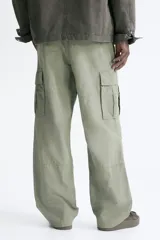 Pantalón cargo de corte relajado confeccionado en lona de algodón. Presenta bolsillos laterales con solapa, bolsillos al bies y bolsillos traseros. Incluye pliegues reforzados en las rodillas y cierre con botón.