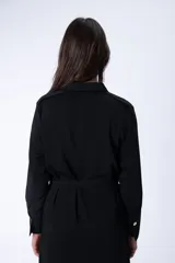 Vestido camisero midi negro con cuello camisero, mangas largas, dos bolsillos en el pecho, cinturón de lazo y abertura lateral.