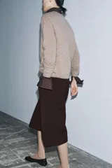 Bermuda larga color marrón oscuro, de tiro medio con cintura con trabillas. Presenta bolsillos laterales ocultos en la costura y detalle de raya planchada. Cierre frontal con cremallera, botón y ganchos metálicos.