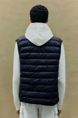 Chaleco acolchado negro con cuello alto, cierre frontal con cremallera y bolsillos laterales con cremallera.