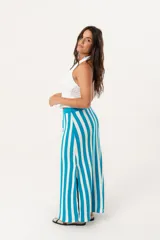 Falda larga tejida a rayas verticales turquesas y blancas, con pretina elástica y tajos laterales.