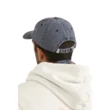 Gorra de visera estilo dad hat en color azul con efecto lavado. Presenta un parche cuadrado en el frente con el logo de la marca Rhythm y detalles en naranja y celeste.