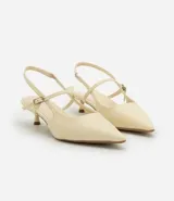 Zapato de tacón color crema, con punta fina, tira delantera y tira trasera con hebilla.