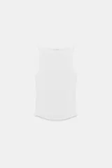 Top blanco de cuello halter, confeccionado en tejido rib con efecto lavado.