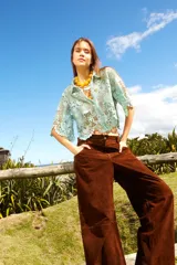 Pantalón de gamuza marrón, corte holgado estilo barrel, con bolsillos laterales y traseros.