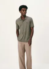 Chomba verde militar melange de manga corta, con cuello polo y cierre frontal de botones, con sutil estampado y ribetes en contraste en cuello y puños.