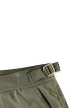 Short de baño con estampado de hojas en tonos verde, marrón y azul sobre fondo azul oscuro.