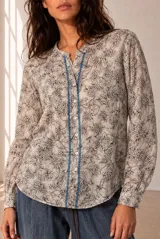 Camisa de manga larga color beige con estampado geométrico y floral en tonos marrones y naranjas, escote en V y botonadura frontal.