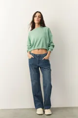 Buzo cropped color verde agua, de manga larga con puños y cordones ajustables en la cintura.