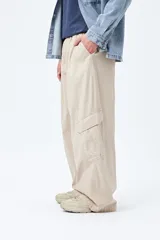 Pantalón cargo color beige, de corte recto y holgado, con cintura elástica y bolsillos laterales con solapa.