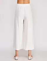 Pantalón palazzo de lino y viscosa, color blanco, de tiro alto y silueta amplia. Presenta pinzas frontales, bolsillos laterales y cierre con botón.