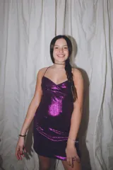 Vestido corto de color verde esmeralda, con escote en pico y breteles finos. Presenta aberturas en los laterales de la cintura y espalda descubierta.