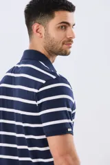 Remera polo de manga corta con diseño de rayas horizontales en color azul marino y rosado. Cuenta con cuello camisero, cierre frontal con botones y calce clásico.