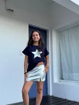 Minifalda dorada de cuero sintético, corte medio/bajo, con cortes en el delantero y pequeño tajo a un lado.