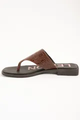 Sandalias de cuero color marrón, tipo ojota con taco bajo, tira ancha con textura trenzada y plantilla con inscripción de la marca.